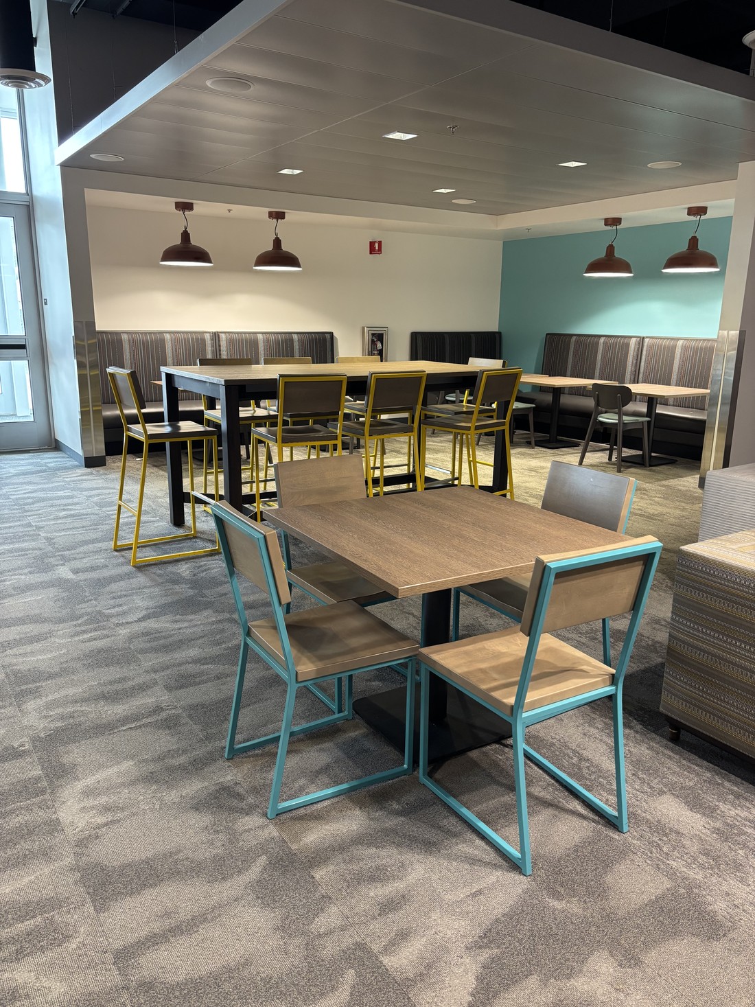 A breakroom and cafeteria seating area at an HM Solutions account, tables cleared and floor cleaned