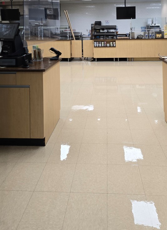 A servery floor with a high gloss finish reflecting the overhead lights