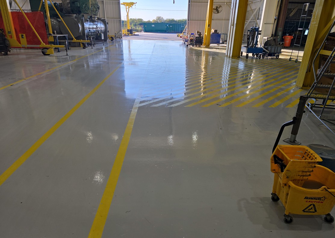 A shop floor mid clean with a mop bucket in frame and the floor still wet